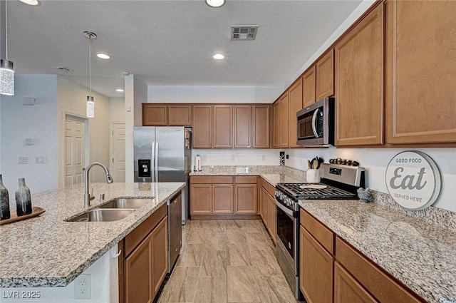 8164 Golden Cholla Ave, Las Vegas, NV 89179 - kitchen featuring stainless steel appliances, a sink, brown cabinetry, light stone counters, and recessed lighting