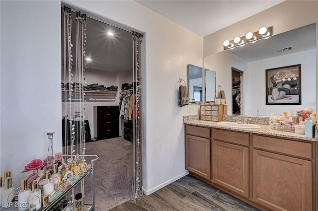 8164 Golden Cholla Ave, Las Vegas, NV 89179 - bathroom with vanity, a walk in closet, and baseboards