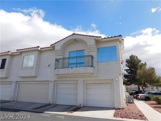 6201 E Lake Mead Blvd Unit 218, Las Vegas, NV 89156 - view of front facade featuring a balcony, an attached garage, stucco siding, and a tiled roof