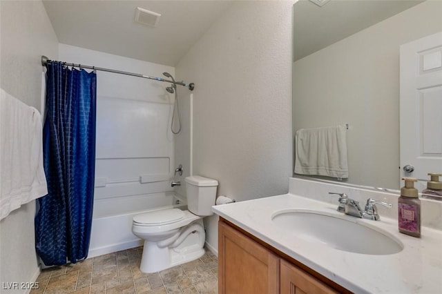 bathroom featuring toilet, vanity, baseboards, stone finish floors, and shower / bathtub combination with curtain