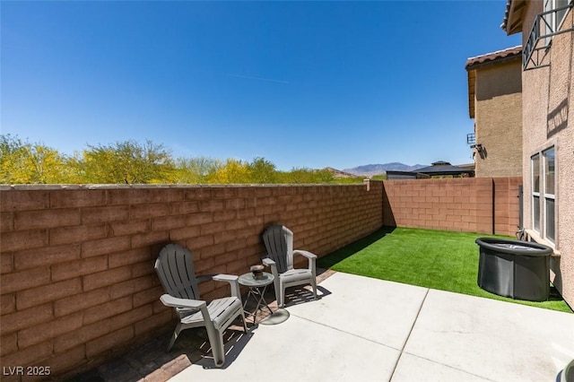 view of patio with a fenced backyard and a mountain view
