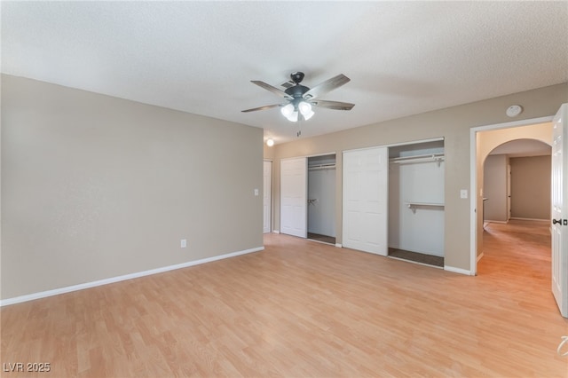 1729 Yellow Rose St, Las Vegas, NV 89108 - unfurnished bedroom featuring arched walkways, light wood-type flooring, two closets, and baseboards