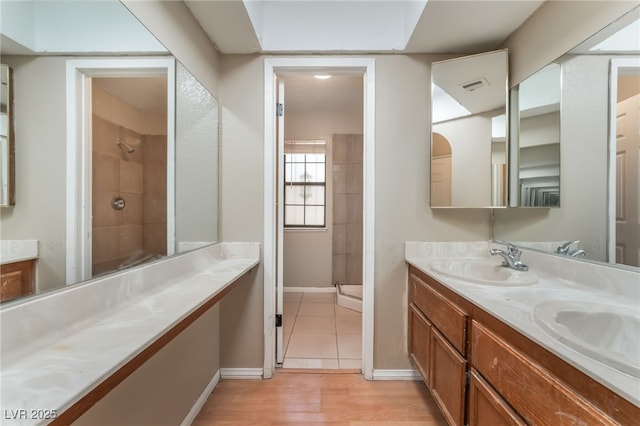 1729 Yellow Rose St, Las Vegas, NV 89108 - bathroom featuring tiled shower, double vanity, baseboards, and wood finished floors