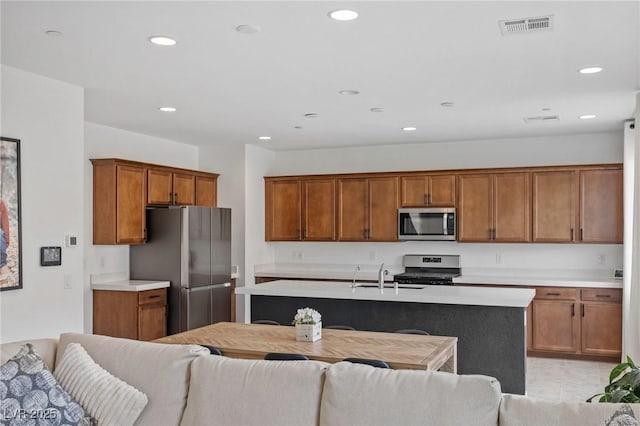 10376 Sadie Blake Ave, Las Vegas, NV 89166 - kitchen with appliances with stainless steel finishes, open floor plan, light countertops, brown cabinetry, and a sink