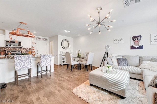 1125 Meadow Sparrow Pl, Henderson, NV 89011 - living room with a chandelier, light wood finished floors, and recessed lighting