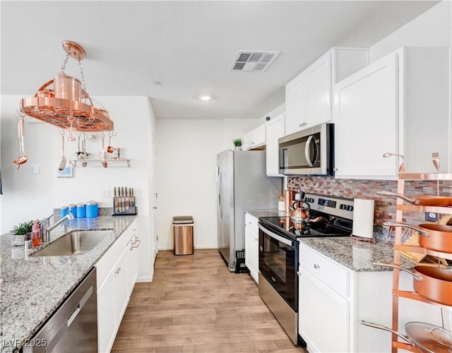 1125 Meadow Sparrow Pl, Henderson, NV 89011 - kitchen featuring stainless steel appliances, light wood-type flooring, a sink, backsplash, and white cabinets