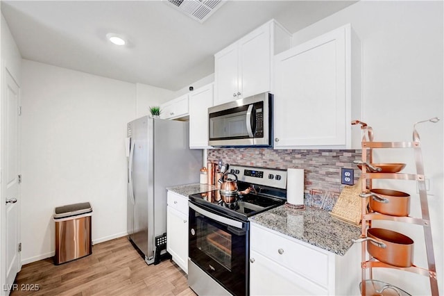1125 Meadow Sparrow Pl, Henderson, NV 89011 - kitchen with stainless steel appliances, backsplash, light stone counters, light wood finished floors, and white cabinets