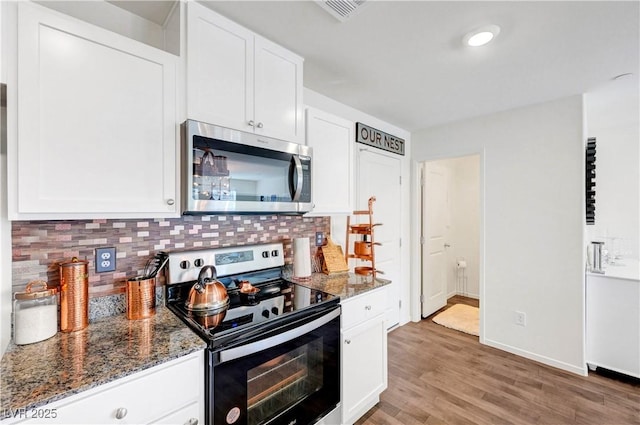 1125 Meadow Sparrow Pl, Henderson, NV 89011 - kitchen featuring stainless steel microwave, range with electric cooktop, backsplash, and dark stone counters
