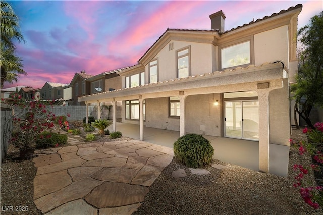 4607 El Camino Cabos Dr, Las Vegas, NV 89147 - back of property at dusk featuring stucco siding, a chimney, and a patio area