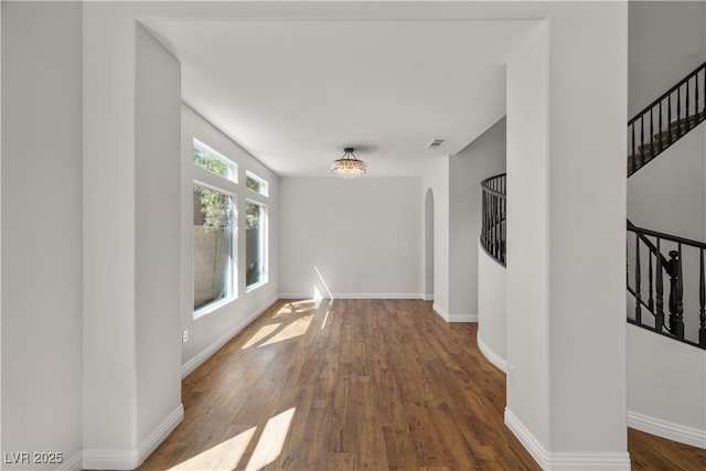 4607 El Camino Cabos Dr, Las Vegas, NV 89147 - corridor with stairway, arched walkways, wood finished floors, and baseboards
