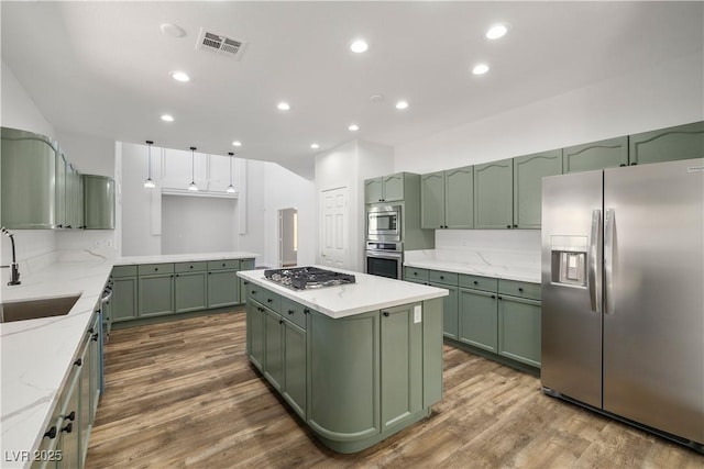 4607 El Camino Cabos Dr, Las Vegas, NV 89147 - kitchen with green cabinets, appliances with stainless steel finishes, a sink, dark wood-style floors, and a kitchen island