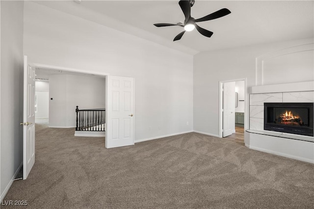 4607 El Camino Cabos Dr, Las Vegas, NV 89147 - unfurnished living room featuring carpet flooring, ceiling fan, baseboards, a fireplace, and high vaulted ceiling