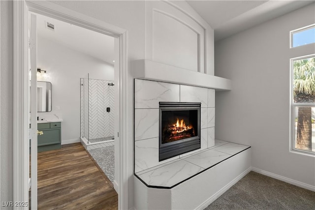 4607 El Camino Cabos Dr, Las Vegas, NV 89147 - detailed view of a high end fireplace, baseboards, and wood finished floors