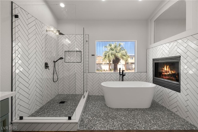 4607 El Camino Cabos Dr, Las Vegas, NV 89147 - full bath featuring a freestanding bath, tiled shower, a glass covered fireplace, tile walls, and recessed lighting