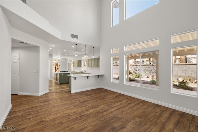 4607 El Camino Cabos Dr, Las Vegas, NV 89147 - unfurnished living room with dark wood-style floors, baseboards, a high ceiling, and recessed lighting