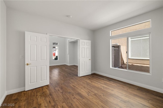 4607 El Camino Cabos Dr, Las Vegas, NV 89147 - unfurnished bedroom featuring multiple windows, wood-type flooring, and baseboards