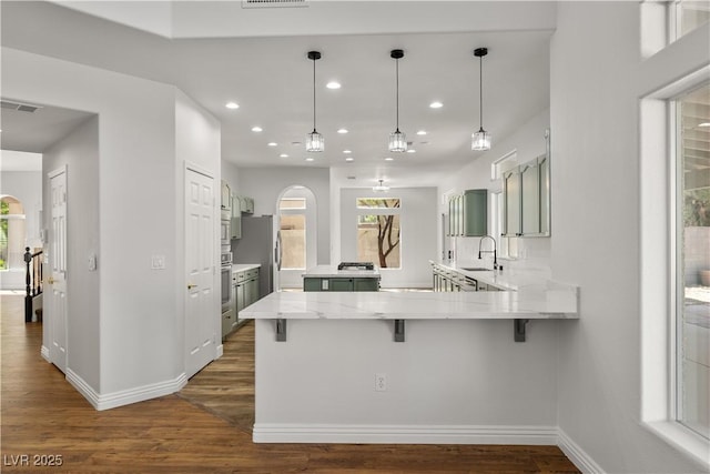 4607 El Camino Cabos Dr, Las Vegas, NV 89147 - kitchen with a peninsula, a sink, dark wood-style floors, recessed lighting, and baseboards