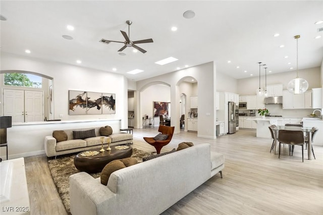 801 Aquitaine Ct, Las Vegas, NV 89145 - living room with arched walkways, a ceiling fan, light wood-style floors, and recessed lighting