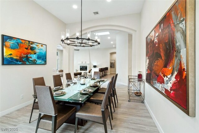 801 Aquitaine Ct, Las Vegas, NV 89145 - dining area with arched walkways, a chandelier, light wood-type flooring, and recessed lighting