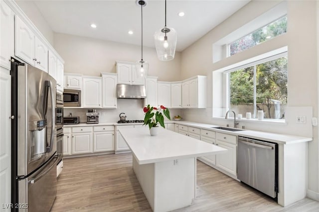 801 Aquitaine Ct, Las Vegas, NV 89145 - kitchen featuring appliances with stainless steel finishes, under cabinet range hood, white cabinetry, a center island, and decorative light fixtures