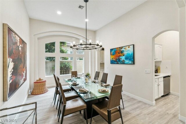 801 Aquitaine Ct, Las Vegas, NV 89145 - dining area with a chandelier, light wood finished floors, arched walkways, and recessed lighting