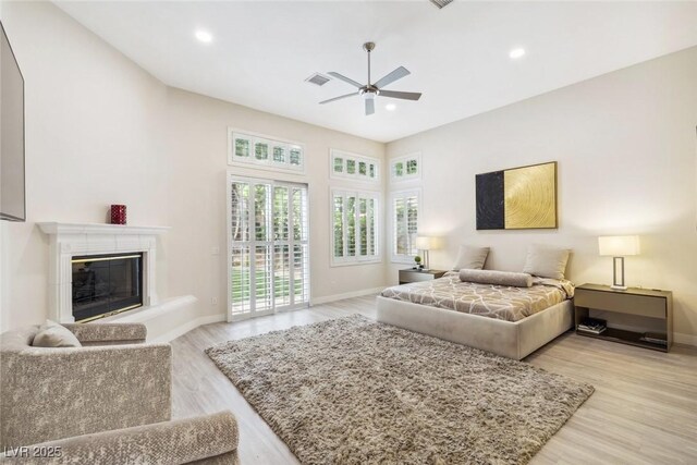 801 Aquitaine Ct, Las Vegas, NV 89145 - bedroom featuring access to exterior, light wood-style flooring, a glass covered fireplace, recessed lighting, and a ceiling fan