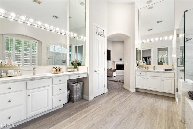 801 Aquitaine Ct, Las Vegas, NV 89145 - full bath with a towering ceiling, a shower stall, two vanities, and wood finished floors