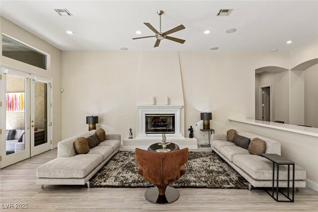 801 Aquitaine Ct, Las Vegas, NV 89145 - living room featuring ceiling fan, light wood finished floors, recessed lighting, a large fireplace, and arched walkways