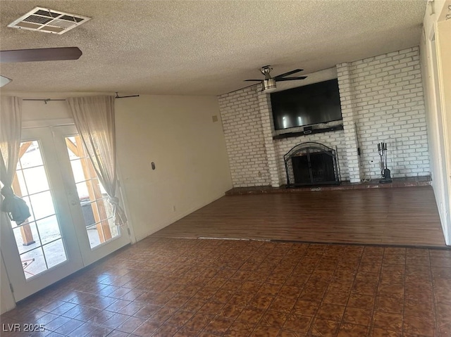 4356 Sabadell St, Las Vegas, NV 89121 - unfurnished living room with ceiling fan, a brick fireplace, a textured ceiling, brick wall, and tile patterned floors