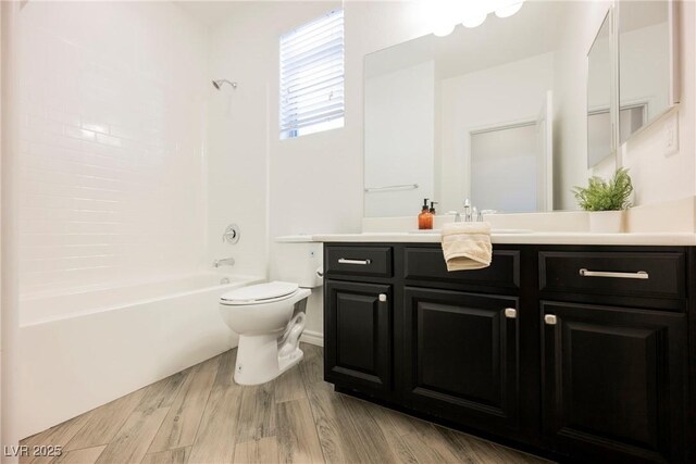 bathroom with toilet, vanity, wood finished floors, and shower / bathtub combination