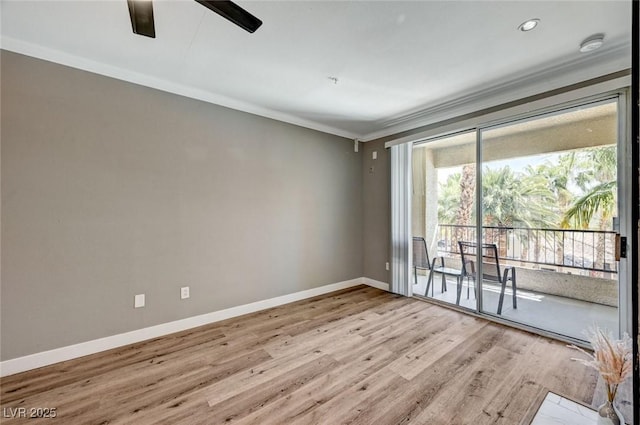 spare room featuring crown molding, baseboards, wood finished floors, a ceiling fan, and a smoke detector
