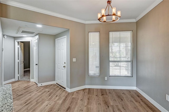 entrance foyer featuring light wood-type flooring, a chandelier, baseboards, and ornamental molding
