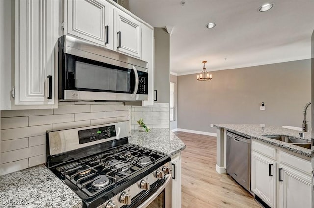 kitchen with stainless steel appliances, a sink, baseboards, white cabinets, and light wood-style flooring