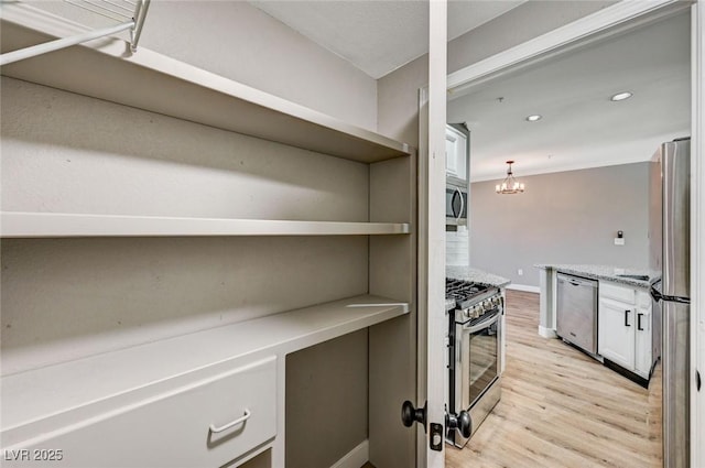 kitchen featuring stainless steel appliances, open shelves, light wood finished floors, white cabinetry, and baseboards