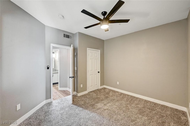 unfurnished bedroom with light colored carpet, baseboards, and ceiling fan