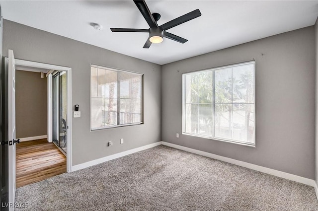 spare room with carpet, ceiling fan, baseboards, and a smoke detector
