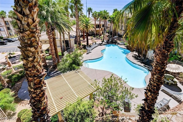 community pool with a patio and fence