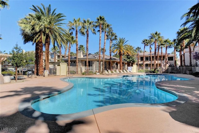 community pool featuring fence and a patio area
