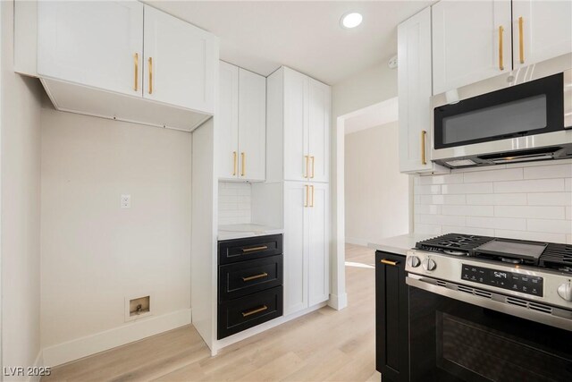 4669 Winfield Dr, Las Vegas, NV 89147 - kitchen with stainless steel appliances, light wood-style flooring, white cabinetry, decorative backsplash, and baseboards