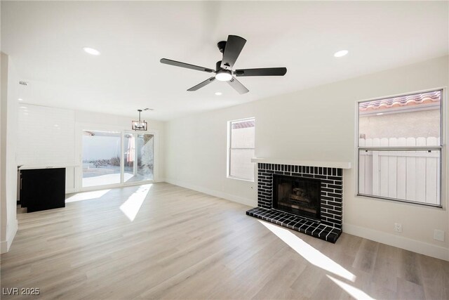 4669 Winfield Dr, Las Vegas, NV 89147 - unfurnished living room with a tiled fireplace, wood finished floors, baseboards, ceiling fan, and recessed lighting