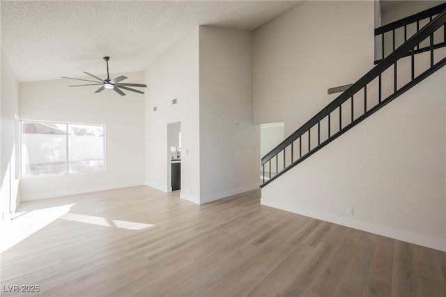 4669 Winfield Dr, Las Vegas, NV 89147 - unfurnished living room with ceiling fan, stairs, wood finished floors, baseboards, and high vaulted ceiling