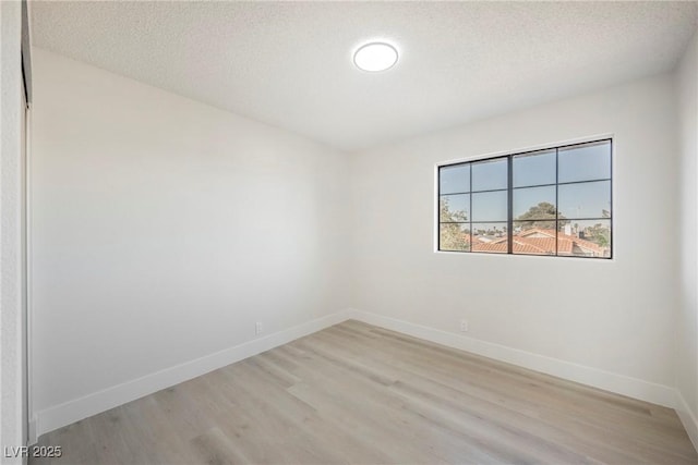 4669 Winfield Dr, Las Vegas, NV 89147 - unfurnished room with light wood finished floors, baseboards, and a textured ceiling
