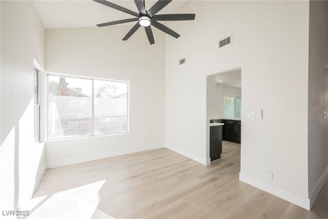 4669 Winfield Dr, Las Vegas, NV 89147 - spare room featuring a ceiling fan, high vaulted ceiling, light wood-type flooring, and baseboards