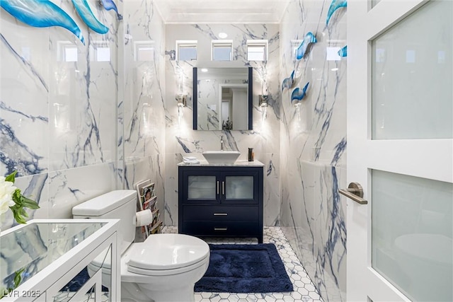 full bathroom with tile walls, toilet, vanity, and a marble finish shower