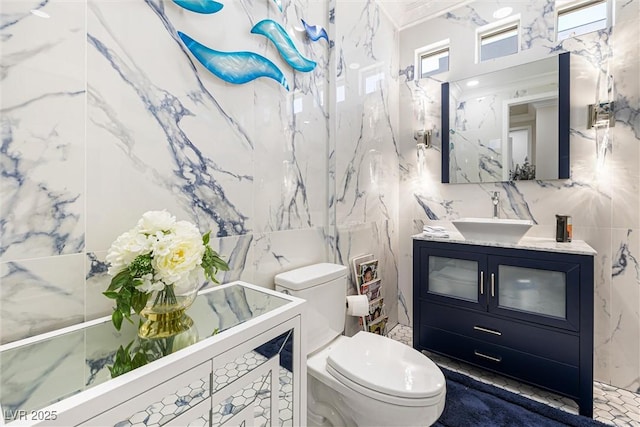 bathroom featuring tile walls, toilet, and vanity