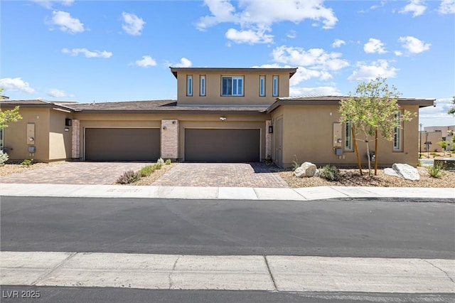 view of front of home featuring decorative driveway and stucco siding