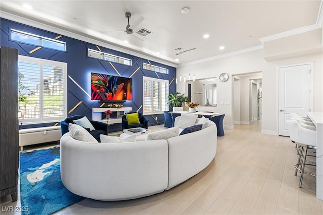 living room with ornamental molding, a ceiling fan, recessed lighting, light wood finished floors, and baseboards