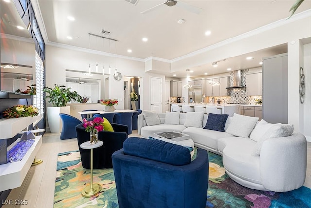 living area featuring ornamental molding, a ceiling fan, and recessed lighting