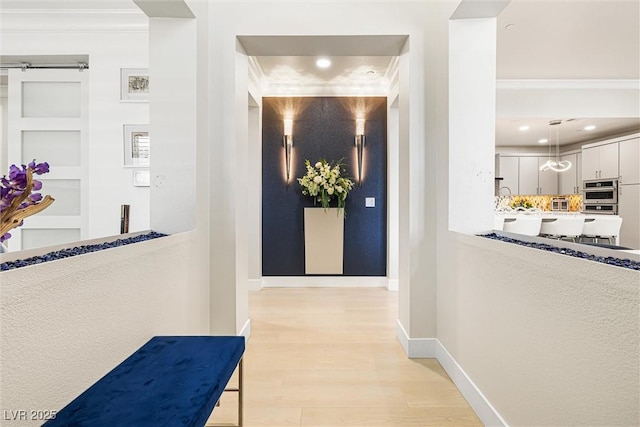 hallway with crown molding, baseboards, light wood finished floors, and recessed lighting
