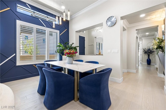 dining room with ornamental molding, light wood-type flooring, and baseboards